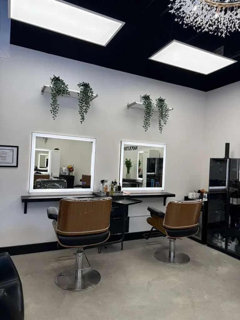 A double suite at MNA Salon Suites: two lit mirrors, two chairs, plants on the shelves